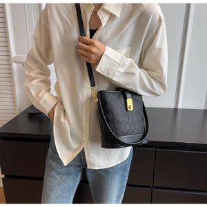 Vue détaillée du sac seau noir en cuir matelassé avec des détails dorés chic