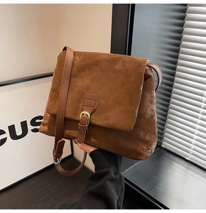 Close-up of vintage brown tote bag with matte texture and decorative metal buckle