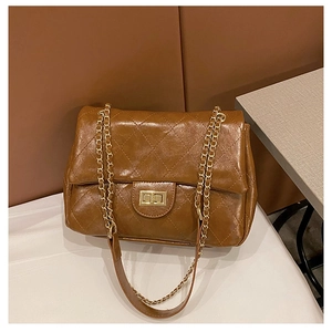 Close-up of brown quilted chain bag with gold metallic twist-lock and premium texture