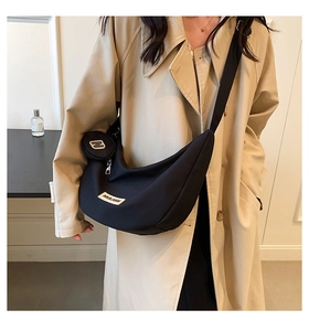 Détail du sac demi-lune en nylon noir avec mini pochette et bandoulière ajustable