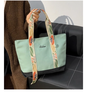 Détail du cabas en toile vert menthe avec broderie Sinichao et bandoulière fleurie