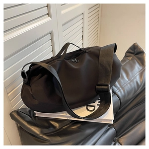 Detail view of black Oxford fabric travel bag with adjustable strap and dual zippers