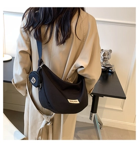 Détail du sac lune en nylon noir montrant un mini porte-monnaie rond amovible avec lettre N
