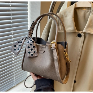 Close-up of khaki bucket bag with lychee grain texture and stylish checkered scarf detail