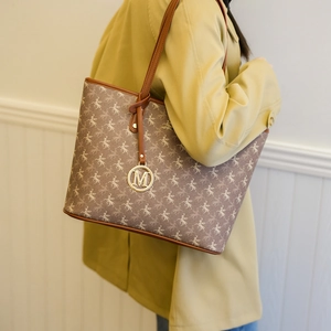 Sac cabas Maillard avec imprimé pégase et pendentif M doré porté par un mannequin