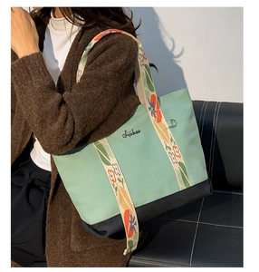 Détail du sac cabas en toile vert menthe avec bandoulière fleurie et logo Sijichao