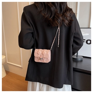 Pink quilted crossbody bag with silver chain strap shown as part of a stylish outfit