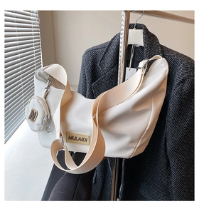Gros plan sur un sac demi-lune blanc avec mini pochette ronde et bandoulière en toile