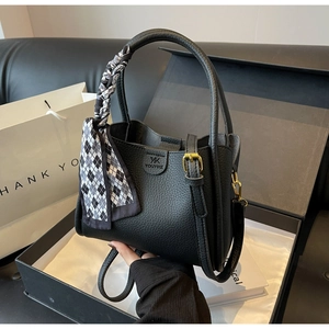Detail of black pebbled leather bucket bag with decorative scarf in a premium gift box