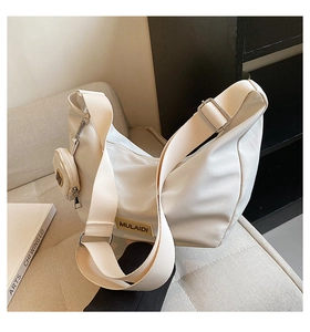 Détail du sac hobo blanc cassé avec large bandoulière et mini porte-monnaie assorti