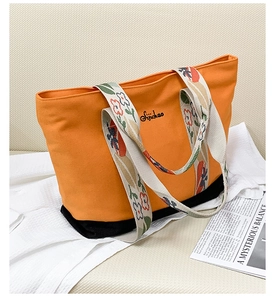 Détail du sac cabas en toile orange avec bandoulière fleurie et logo brodé Sipchao