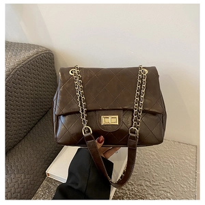 Detailed view of the dark brown quilted leather bag with golden metal twist lock