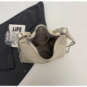 Detail of off-white shoulder bag interior with mesh pockets and zipper closure