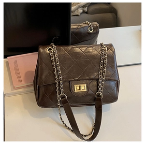 Detailed view of brown quilted crossbody bag with gold metallic twist lock and chain strap
