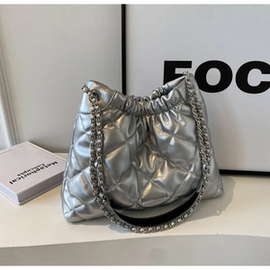Detailed close-up of quilted silver chain bag showing metallic texture and brand logo