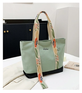 Détail du sac cabas en toile vert menthe avec bandoulière à fleurs et broderie
