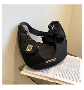 Détail du sac bandoulière croissant noir avec sangle large et mini porte-monnaie