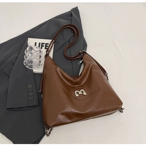 Detail of caramel brown hobo bag showing pleated glossy leather and silver M logo