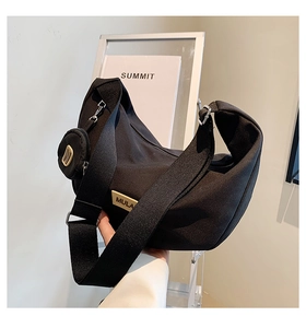 Détail du sac demi-lune en nylon noir avec bandoulière large et petit porte-monnaie