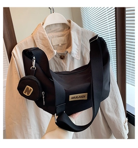 Détail du sac lune en nylon noir avec écusson MULAIDI et petite pochette ronde