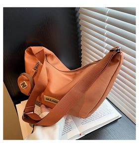 Détail du sac demi-lune en nylon orange avec mini pochette et bandoulière large