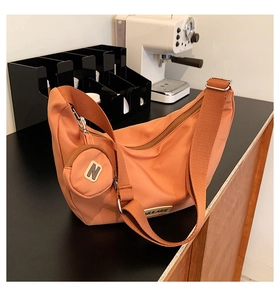 Détail du sac demi-lune en nylon terre cuite avec mini pochette ronde et boucle argent