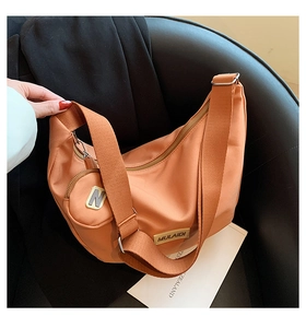Détail du sac hobo orange avec bandoulière large et petit porte-monnaie assorti