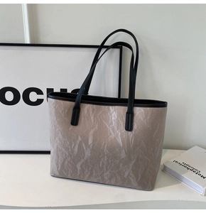 Detail of minimalist tote bag showing unique pleated texture and black contrast handles