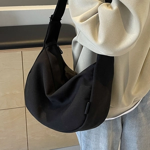 Minimalist black canvas crescent crossbody bag with wide shoulder strap for women