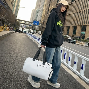 Grand sac de voyage blanc imperméable en Oxford porté par un mannequin en milieu urbain