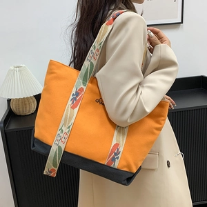 Sac fourre-tout en toile orange et noir avec bandoulière brodée de motifs floraux