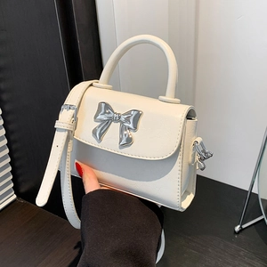 Cream white faux leather crossbody bag with silver metal bow and adjustable strap
