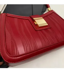 Detailed view of red wedding handbag with chevron embossed leather and gold clasp