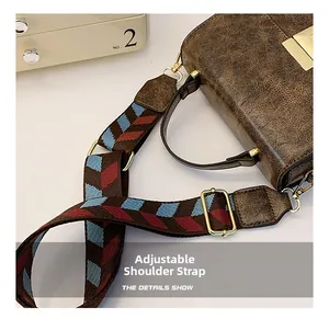 Detail of colorful geometric woven shoulder strap and vintage textured leather on brown bag