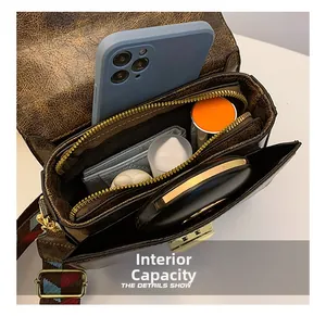 Deep brown vintage leather bag interior showing capacity for phone, wallet and cosmetics