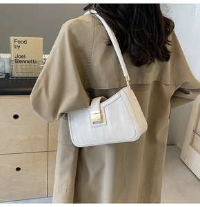 Vertical wave textured white shoulder bag with gold rectangular clasp on model