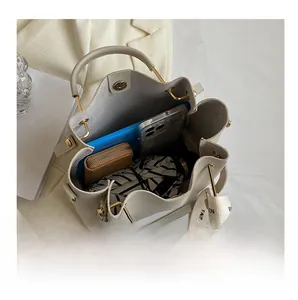 Detailed interior of a beige bucket bag showing large capacity for phone and umbrella
