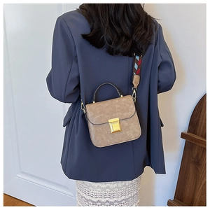 Close-up of khaki retro crossbody bag with textured leather and ethnic wide strap