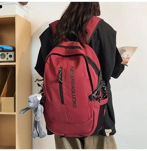 Deep red backpack detail showing nylon texture and vertical graphic print on the back