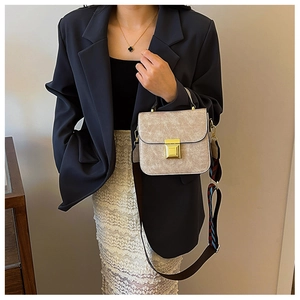Detail of grey marble texture crossbody bag with gold buckle and striped wide strap