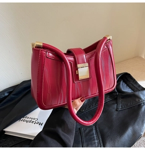 Detail view of red bridal handbag featuring elegant wave texture and gold square lock
