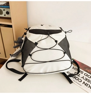 Detail view of large capacity student backpack with black bungee cords and side mesh pockets
