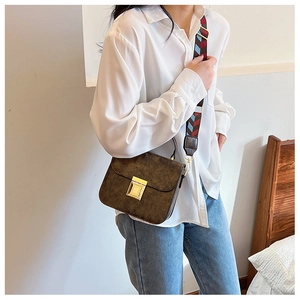 Detail of vintage dark brown crossbody bag with colorful woven wide shoulder strap