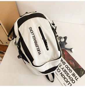 Close-up of black and white large capacity backpack with side pocket and plush pendant