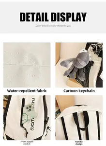 Close-up of waterproof black and white backpack with front zipper and cartoon pendant