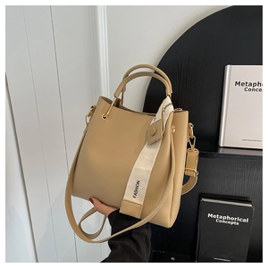 Detail of khaki bucket bag with wide canvas strap featuring fashion embroidery detail