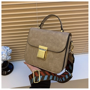 Detail of vintage brown shoulder bag with gold square buckle and patterned strap