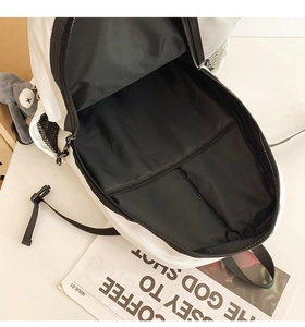 Top view of spacious backpack interior with black lining, zipper detail and bunny charm