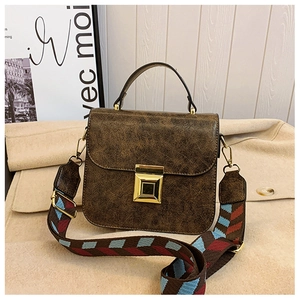 Detail of vintage brown cracked-texture handbag with geometric pattern wide strap