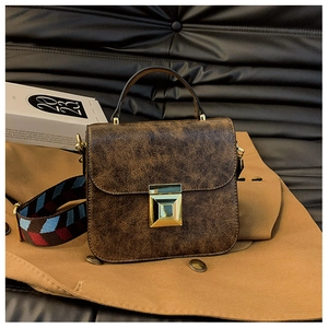 Detail of vintage brown crossbody bag with crackle texture and woven strap